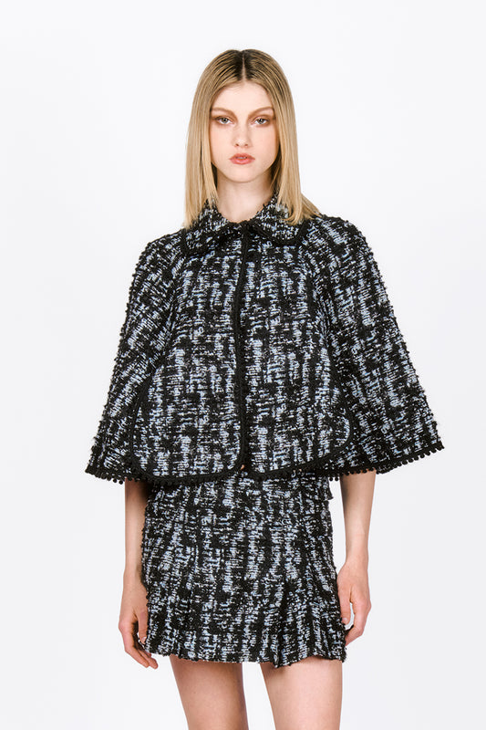 Cornflower Tweed Cape, waistline long, open in front, black laced on hems, rounded flap collar.